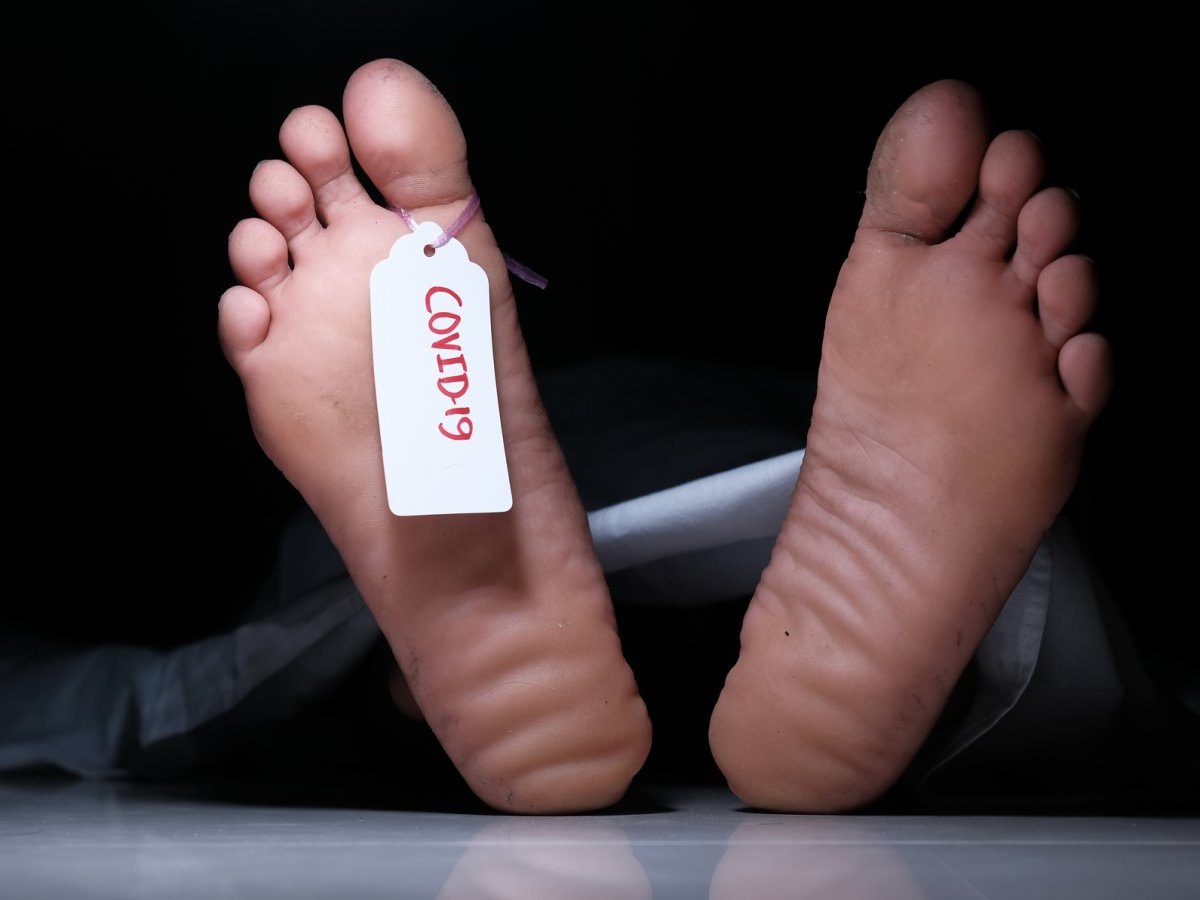 Füße mit "COVID-19"-Schild