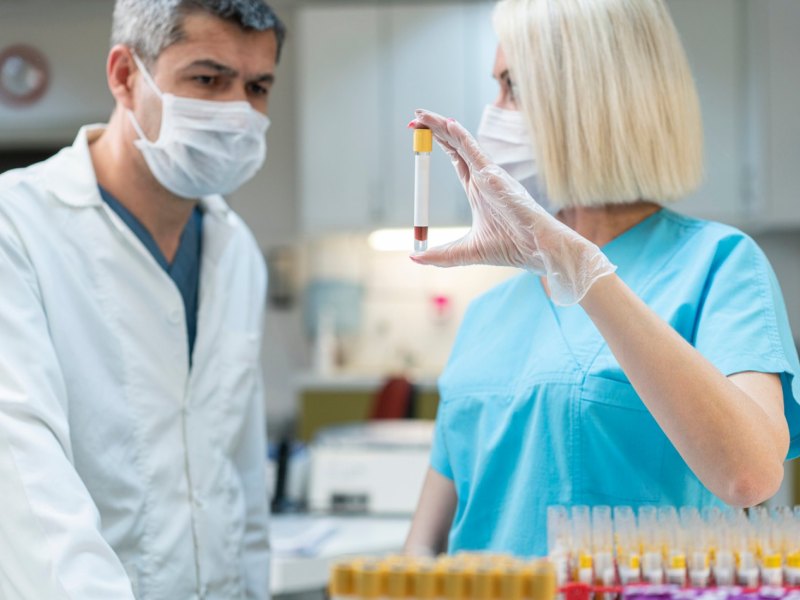 Zwei Labortechniker mit einer Probe.