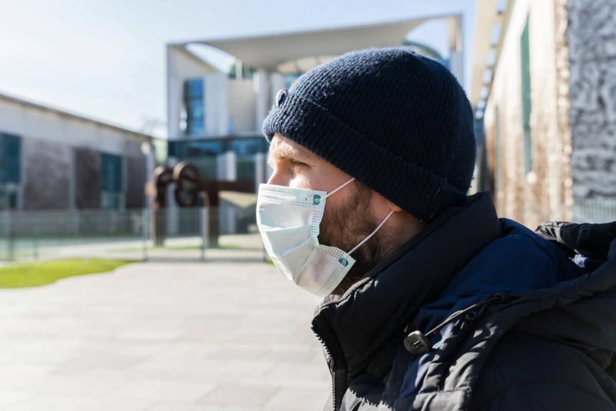 Mann mit Mundschutz vor dem Bundeskanzleramt in Berlin.