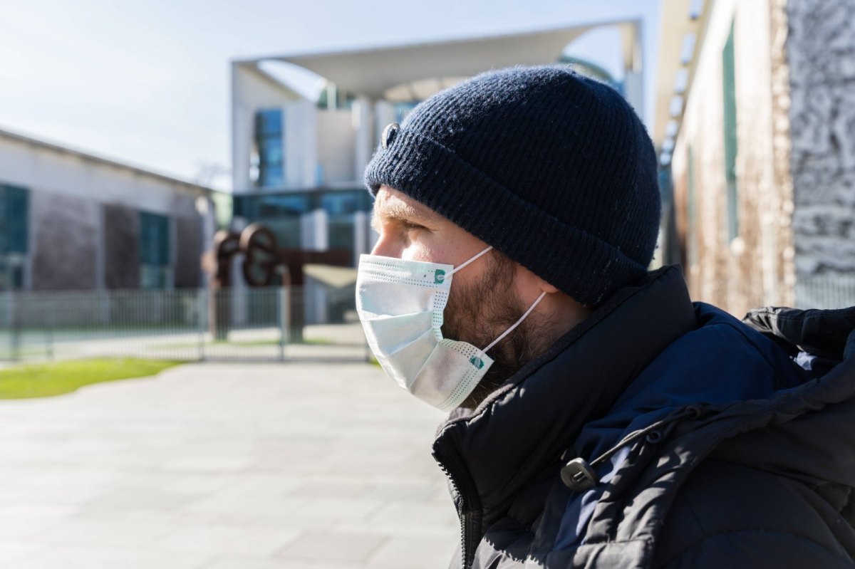 Mann mit Mundschutz vor dem Bundeskanzleramt in Berlin.