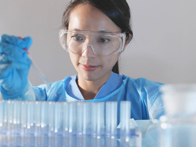 Wissenschaftlerin in einem Labor mit einer Spritze in der Hand.