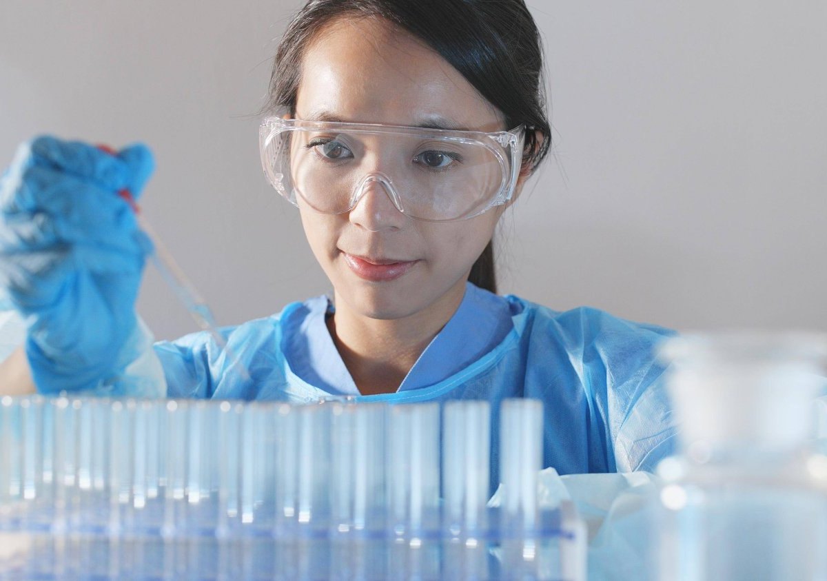 Wissenschaftlerin in einem Labor mit einer Spritze in der Hand.