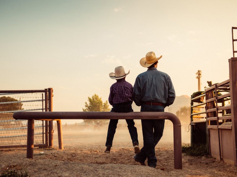 Vater und Sohn in Rodeo arena.