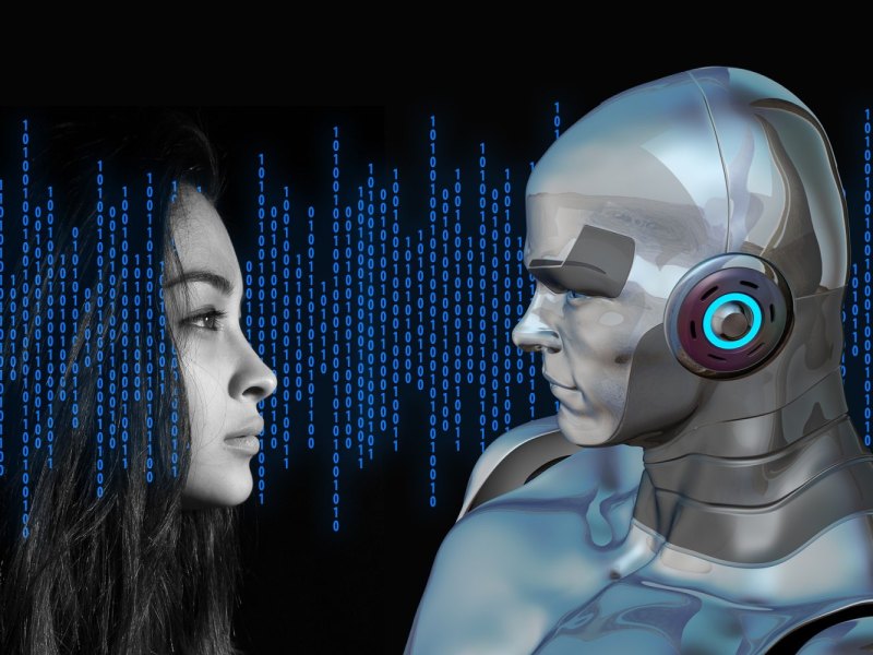 Gesicht einer Frau schaut in das Gesicht eines Roboters