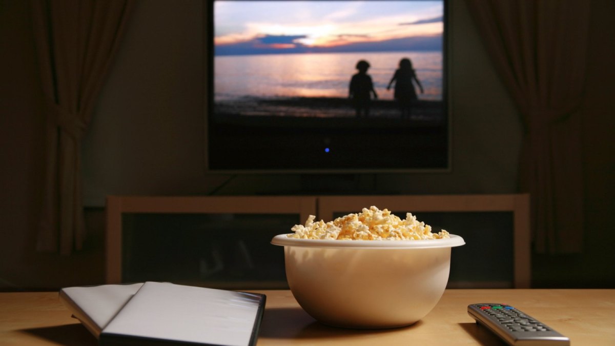 DVD-Hülle und Popcorn auf dem Couch-Tisch vor dem TV.