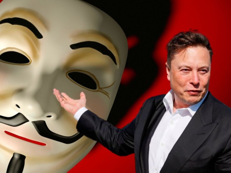 Elon Musk vor einer Guy Fawkes-Maske