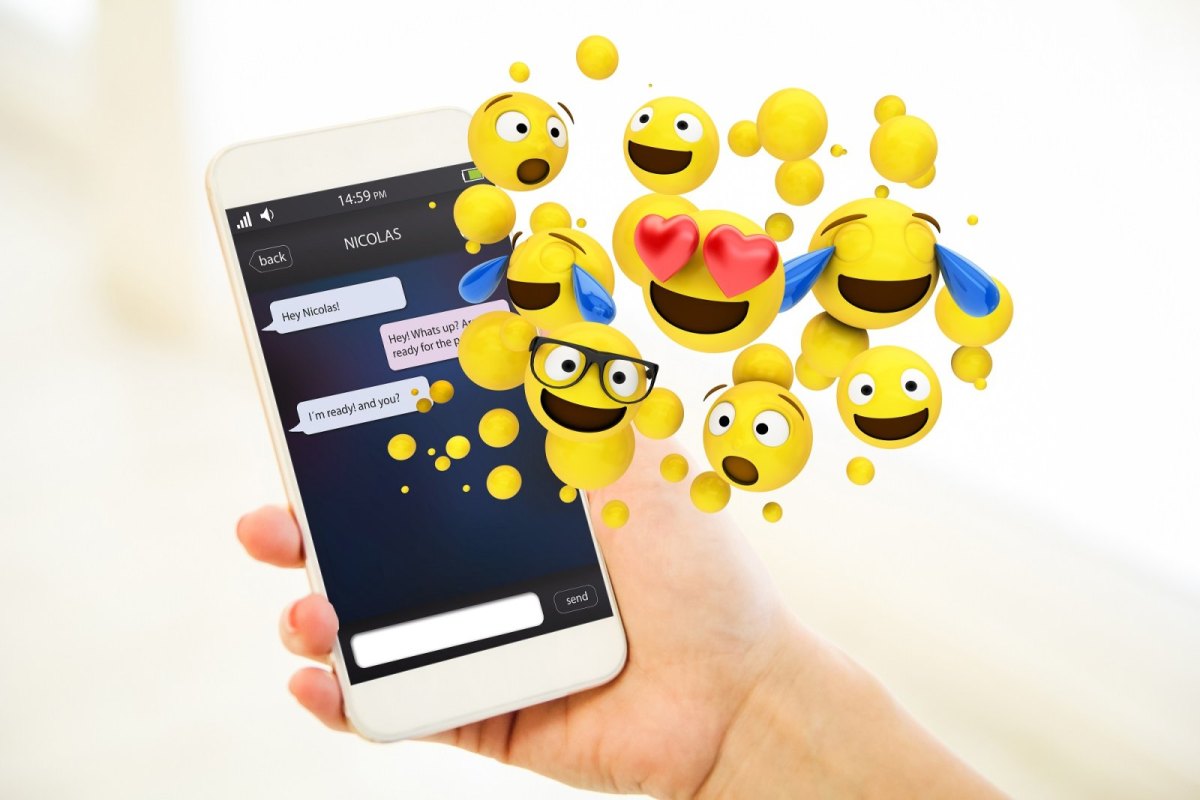 Emojis kommen aus dem Bildschirm eines Handys.