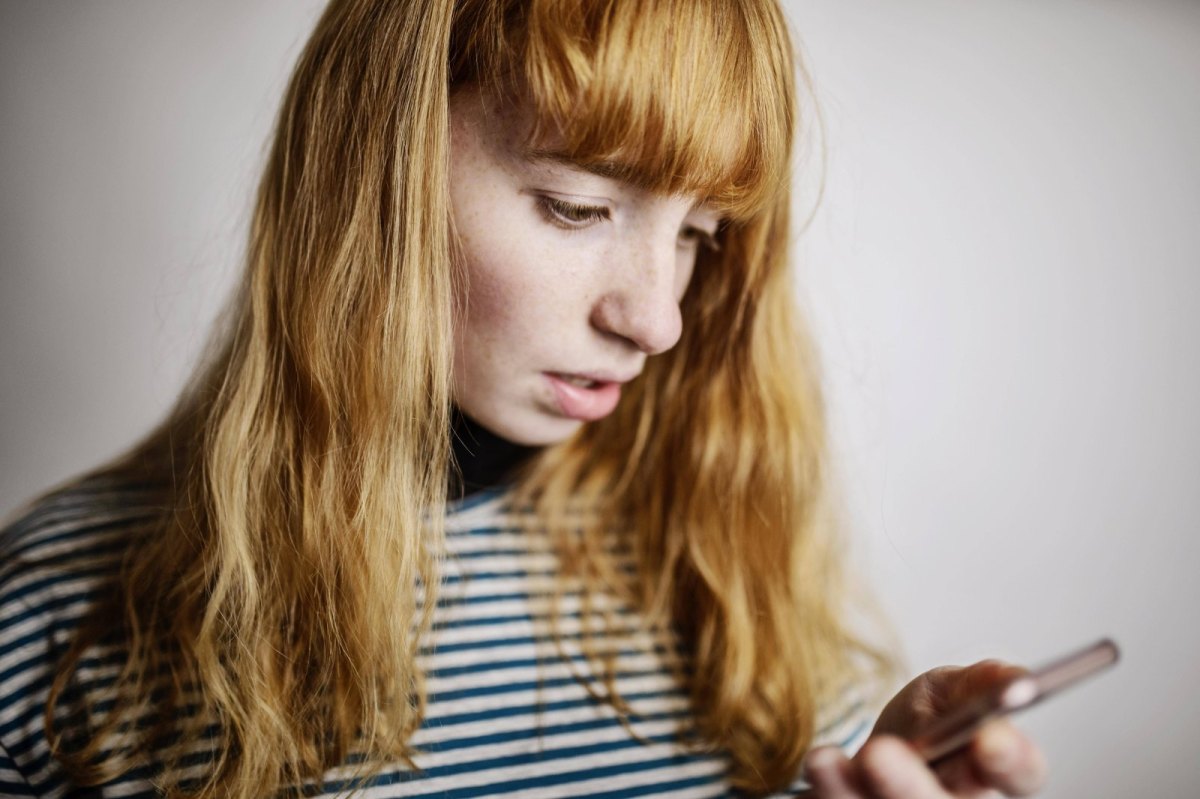 Frau schaut enttäuscht aufs Handy