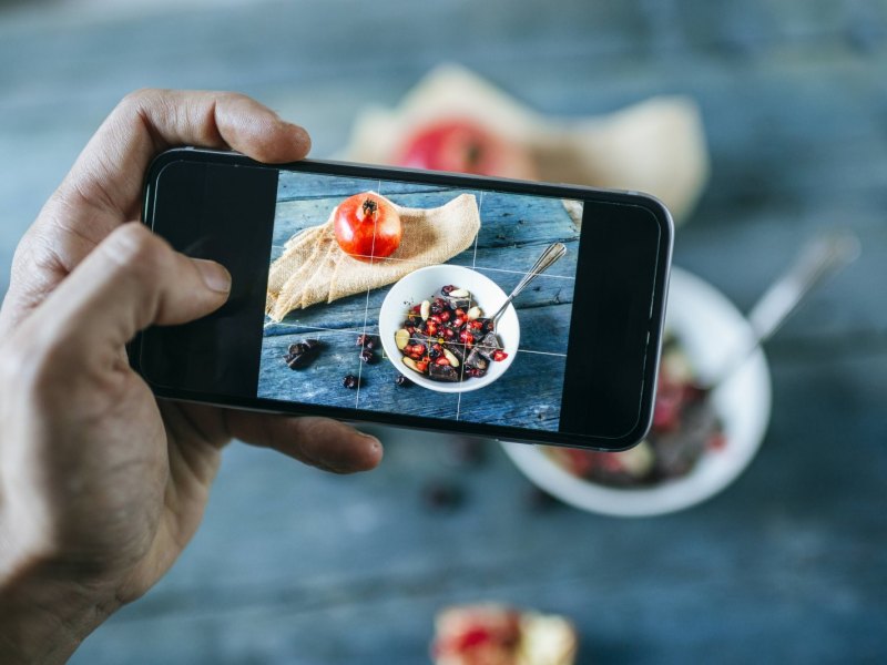 Person fotografiert Essen mit dem Handy