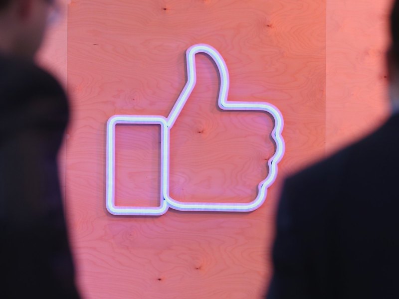 Facebooks Like-Symbol als Leuchtmittel an einer Wand