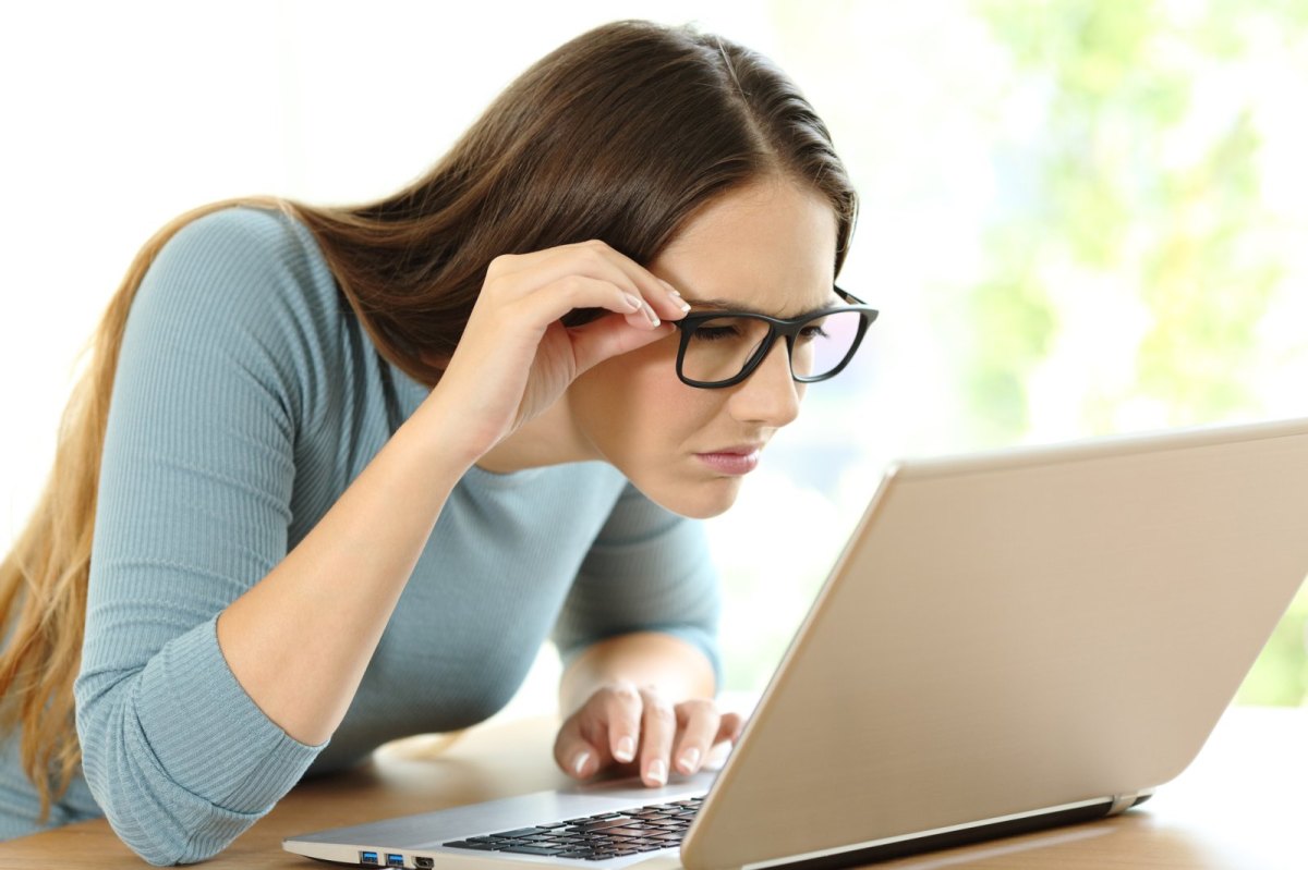 Frau schaut skeptisch auf ihren Laptop