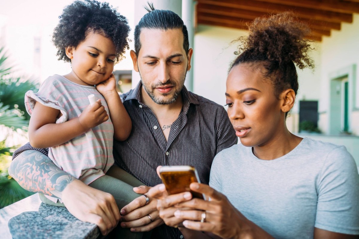 Dreiköpfige Familie mit Smartphone
