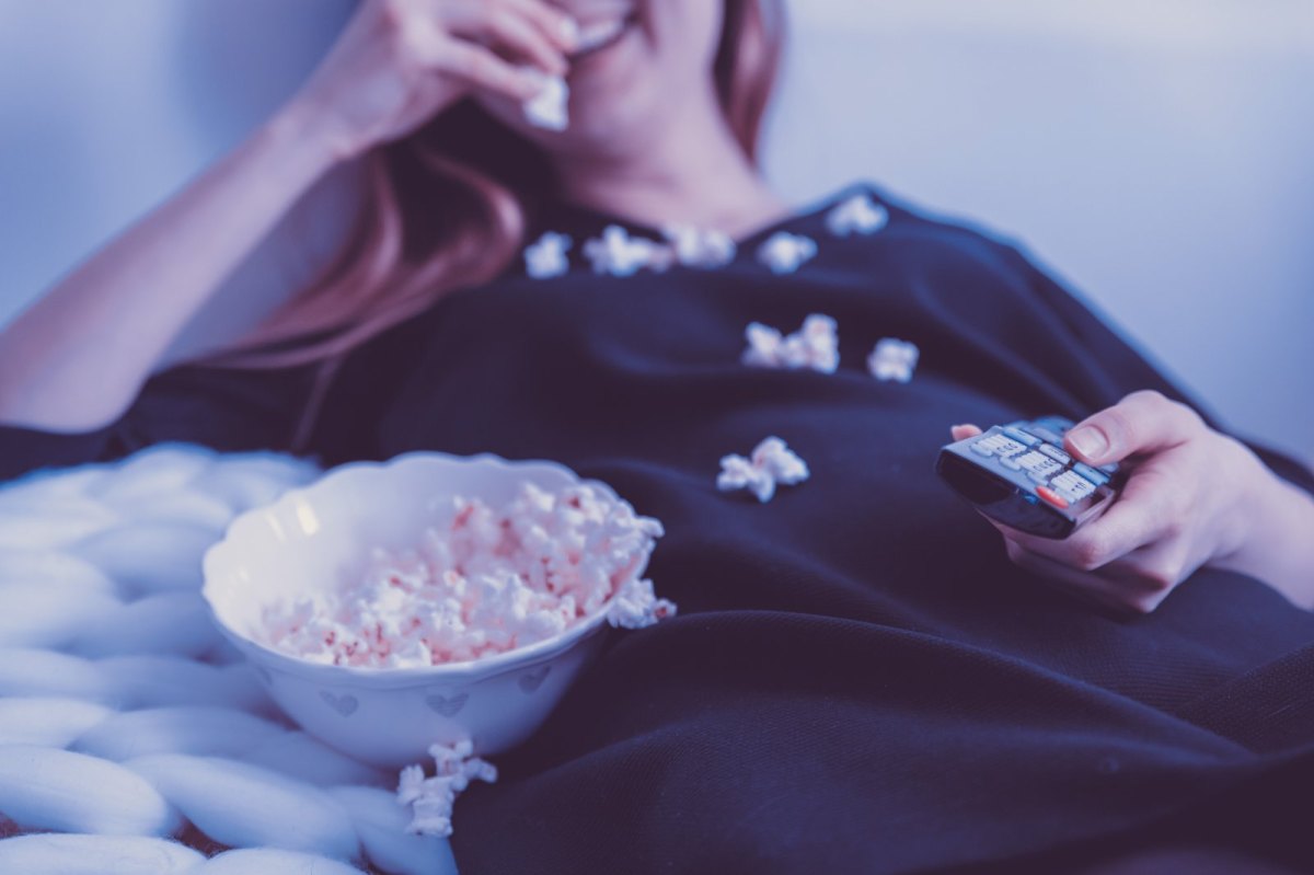 Frau schaut mit Popcorn Film