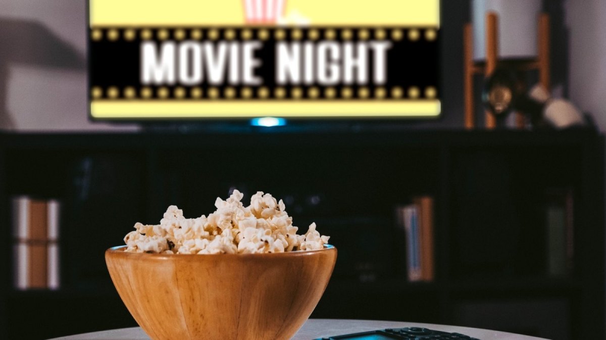 Popcorn auf dem Tisch vor dem TV mit Movie Night-Aufschrift.