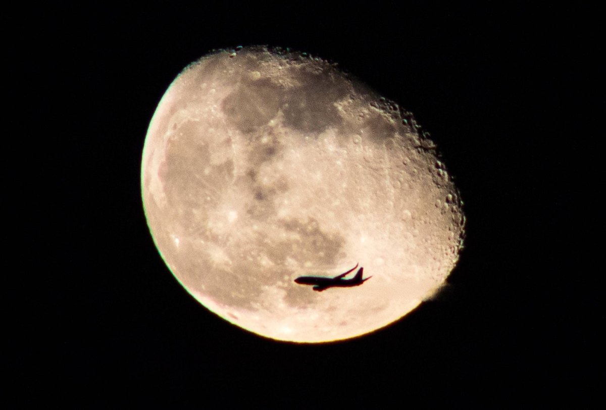 Flugzeug vor dem Mond fotografiert