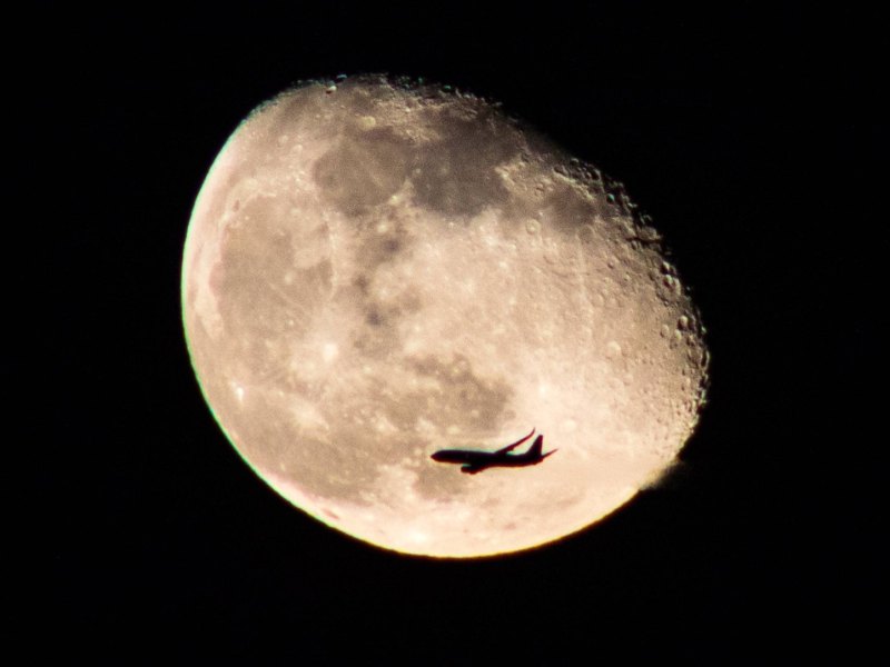 Flugzeug vor dem Mond fotografiert