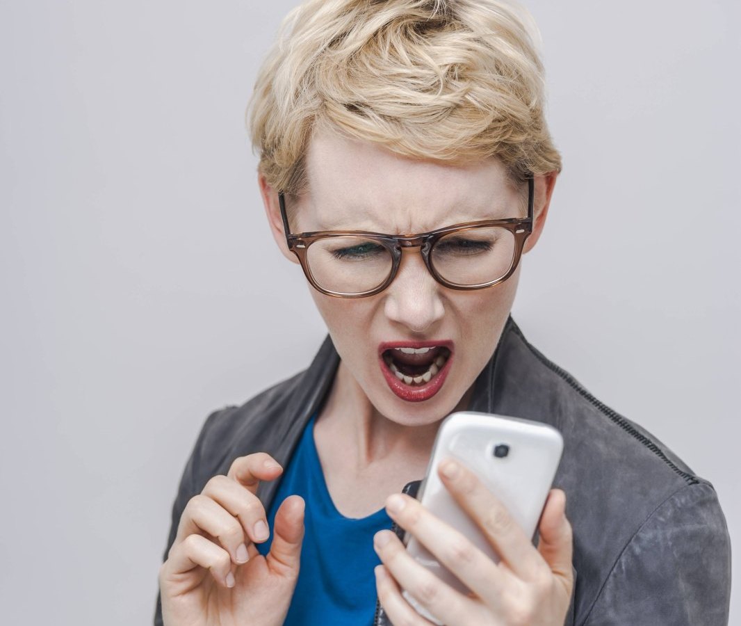 Frau schreit Handy an