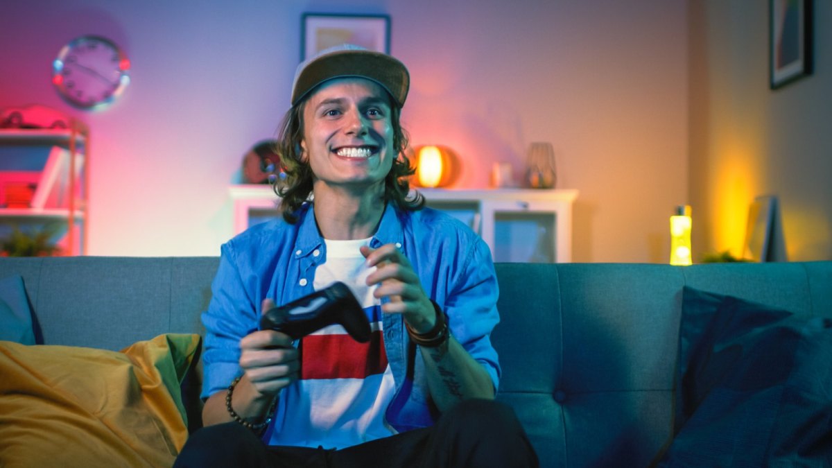 Grinsender Mann mit PS4-Controller