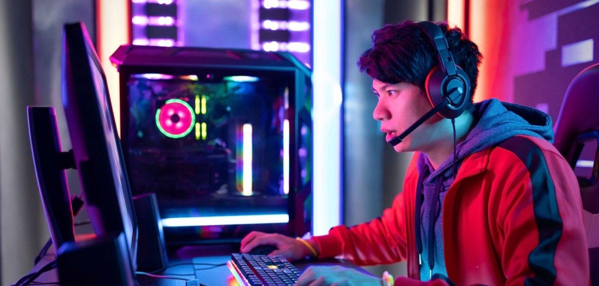 Mann mit Gaming-PC vor einem Monitor