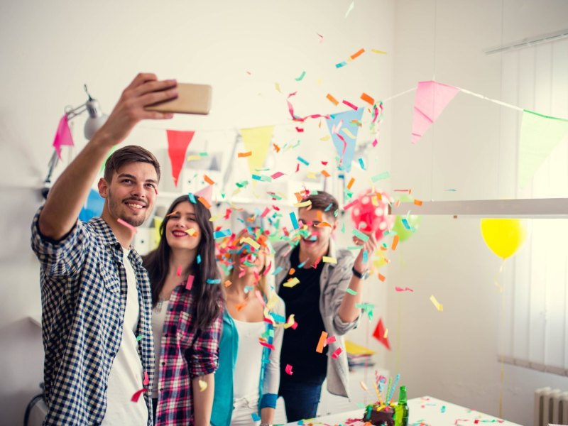 Freunde machen bei einer Geburtstagsfeier ein Selfie.