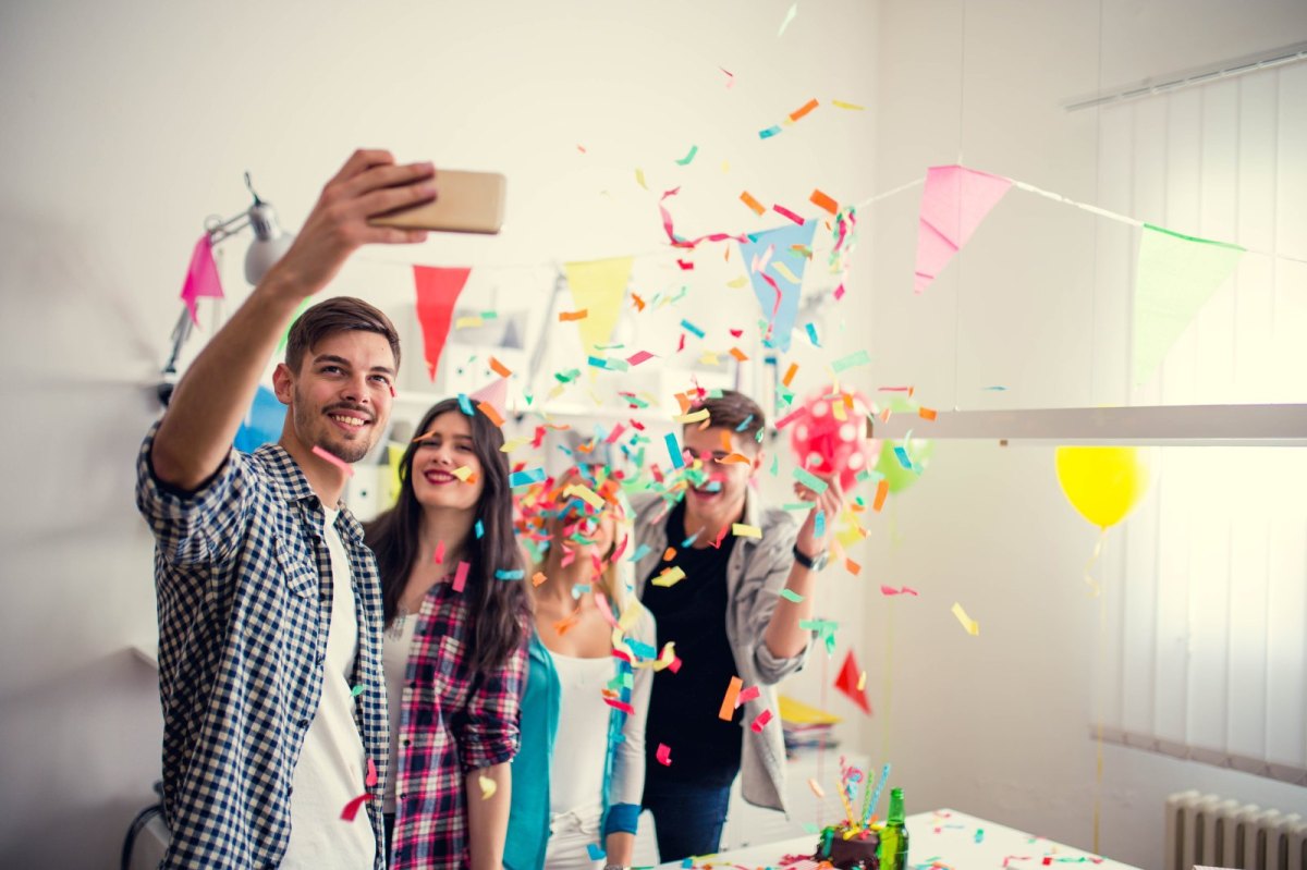 Freunde machen bei einer Geburtstagsfeier ein Selfie.