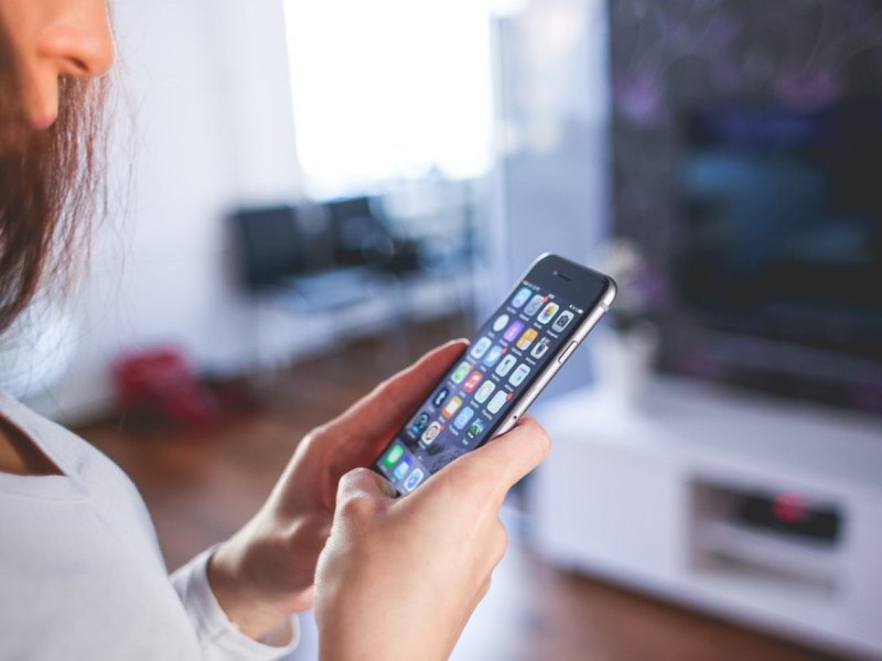 Eine Frau mit einem Smartphone in der Hand.