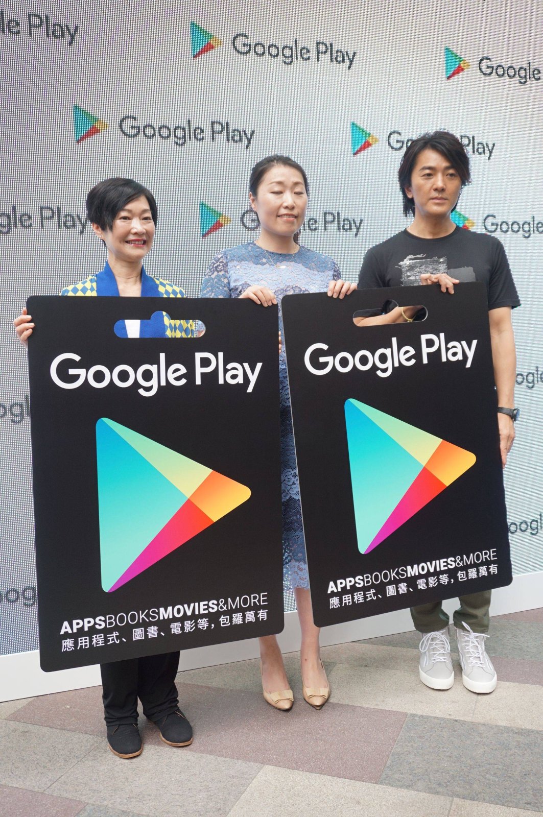 Drei Personen halten Schilder mit dem Google Play-Logo hoch.