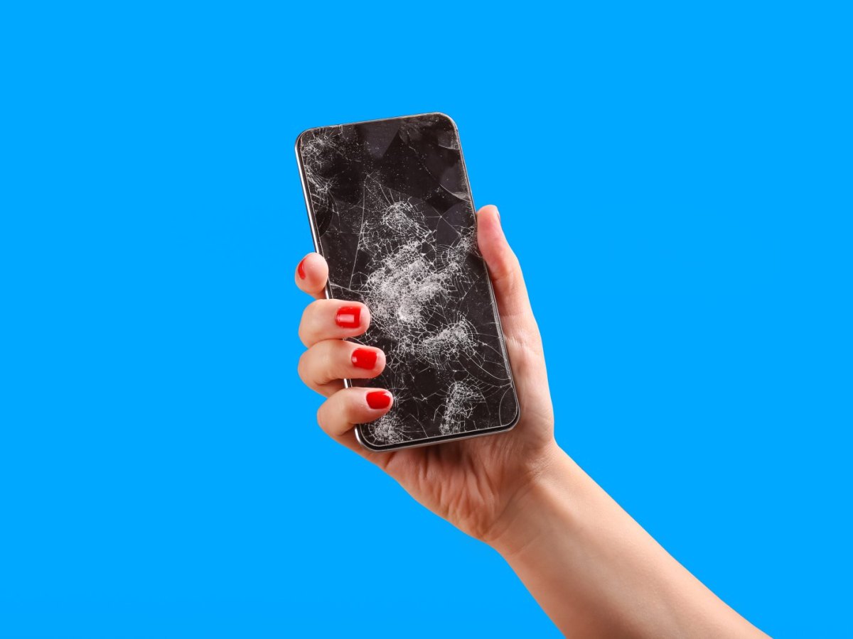 Frau Hält ein kaputtes Handy in der Hand