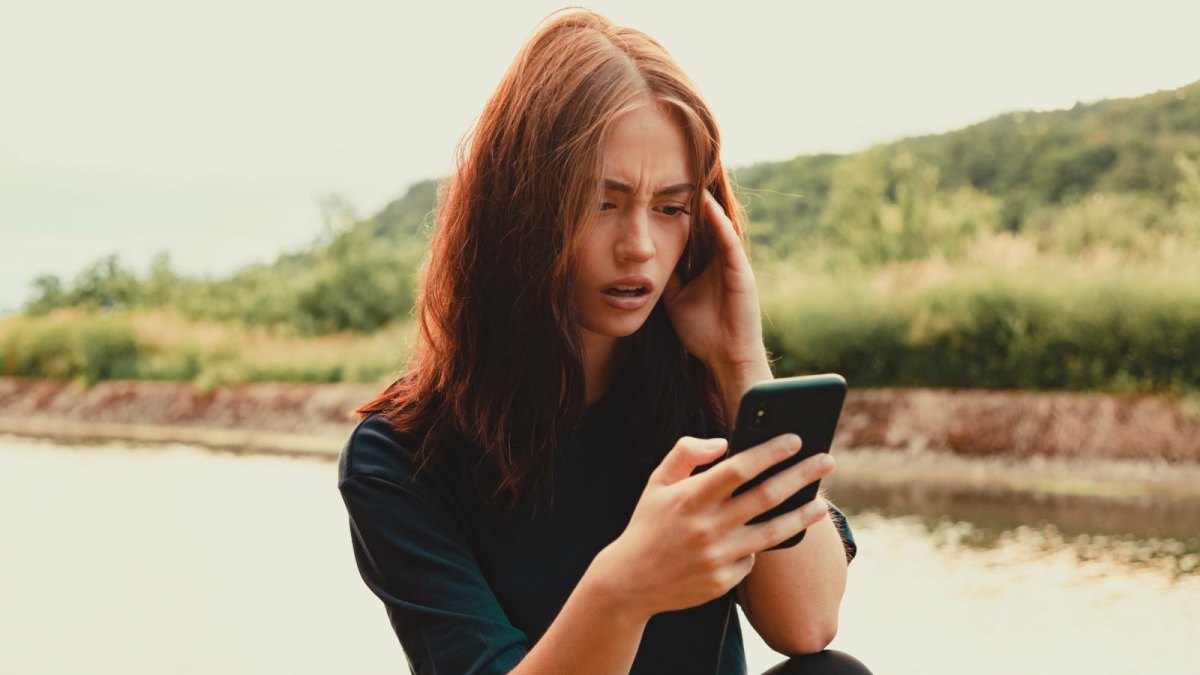 Frau erschrocken am Handy