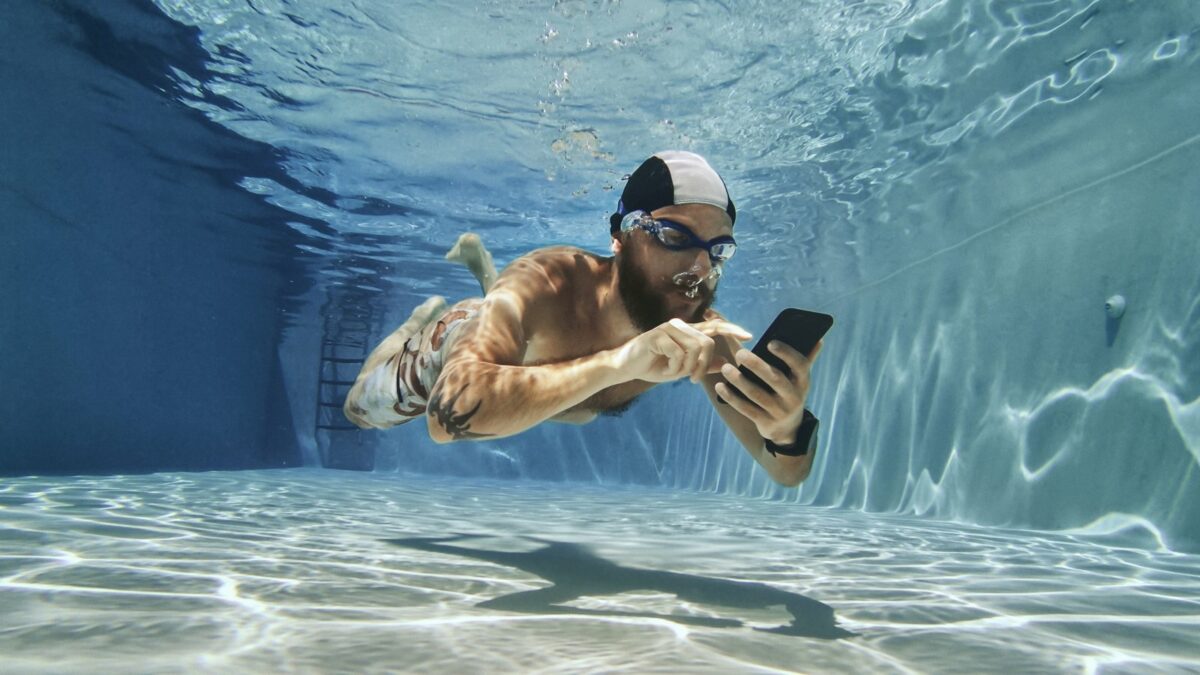 Mann unter Wasser mit Handy