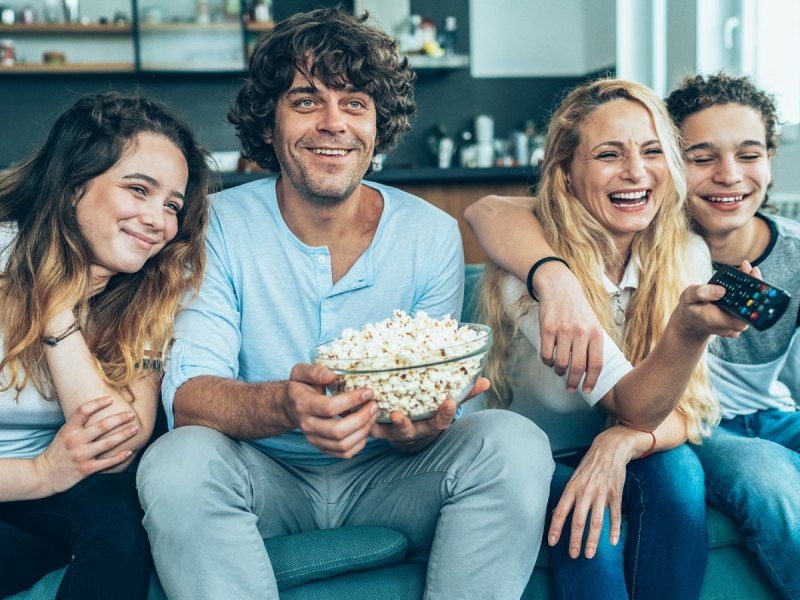 Vier Freunde glücklich vor dem TV.