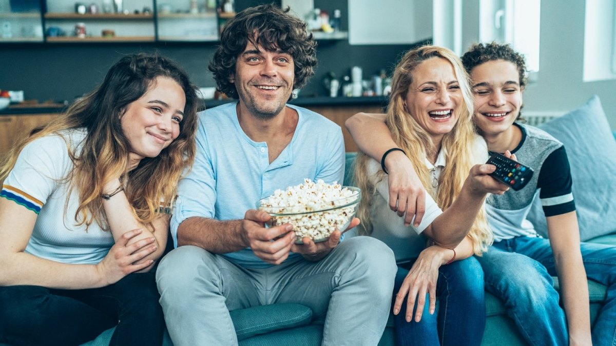 Vier Freunde glücklich vor dem TV.