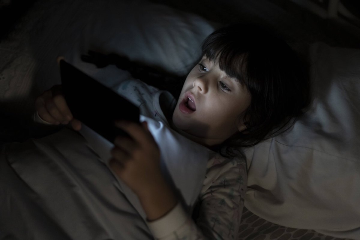 Mädchen im Bett mit einem Smartphone in der Hand