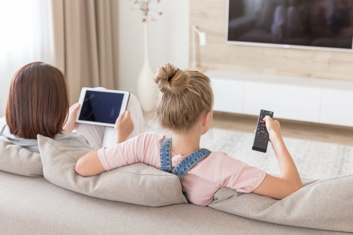 Mädchen mit iPad vor dem Fernseher