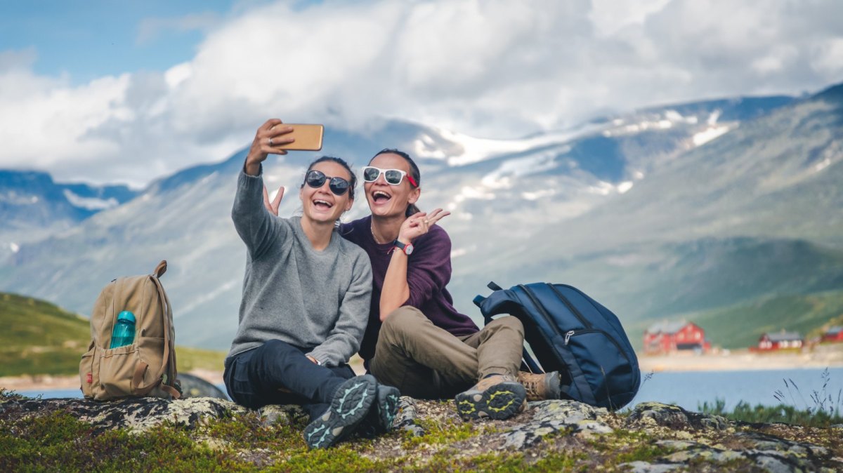 Zwei Frauen machen in den Bergen ein Selfie.