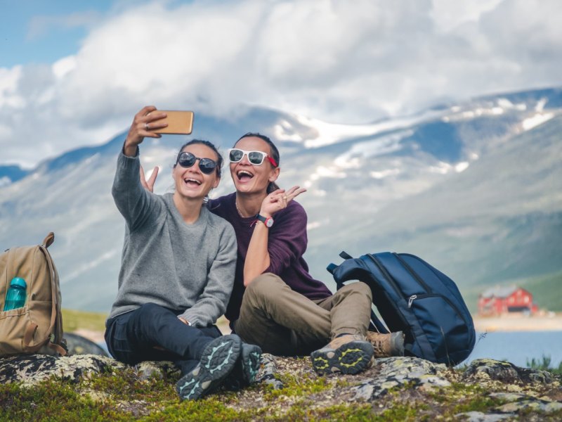 Zwei Frauen machen in den Bergen ein Selfie.