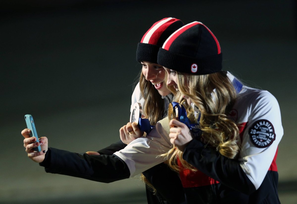 Zwei Frauen mit Olympia-Medaillen schießen mit dem iPhone ein gemeinsames Selfie