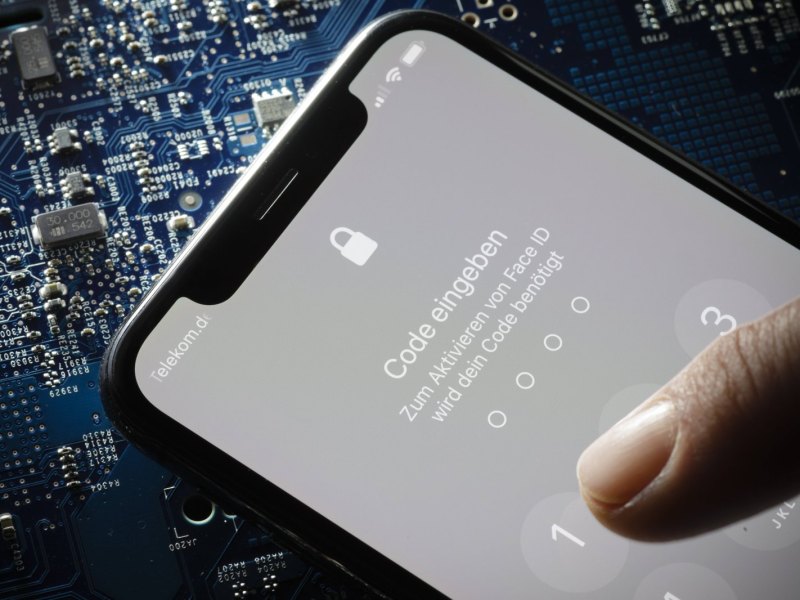 Person tippt iPhone-PIN ein