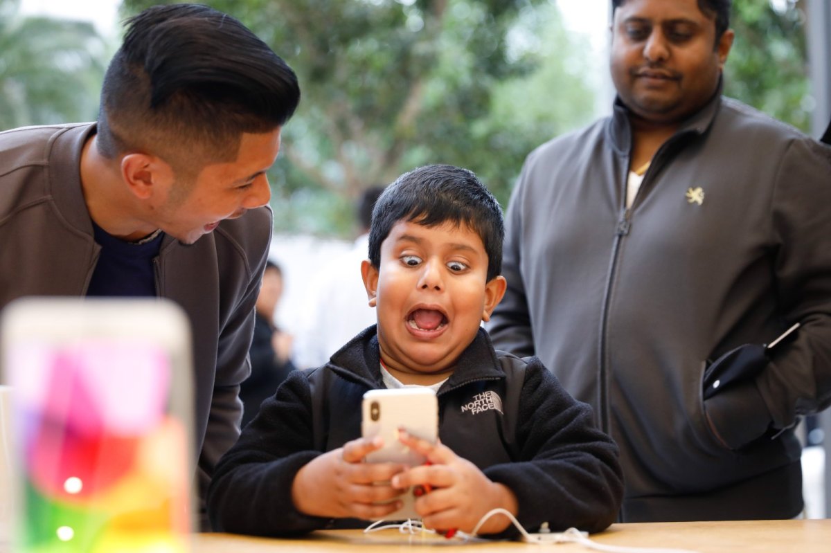 Junge hält iPhone X in der Hand und verzerrt das Gesicht