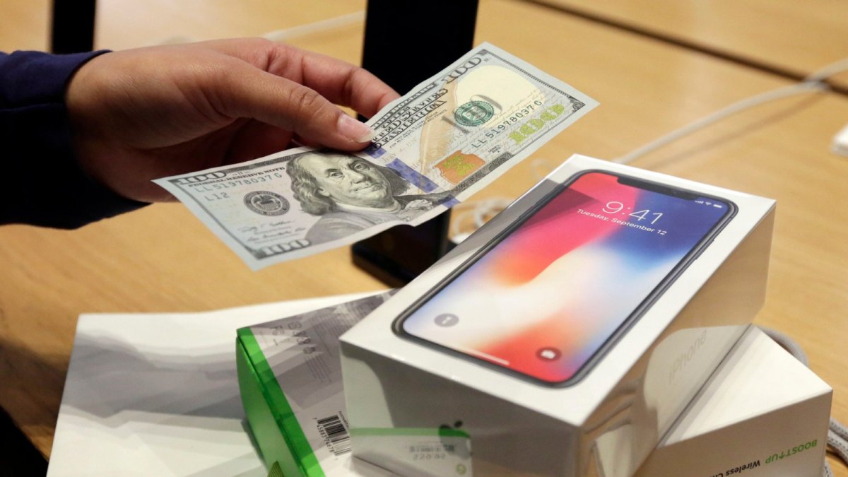 Kunde bezahlt ein iPhone X im Apple Store mit einem Geldschein.