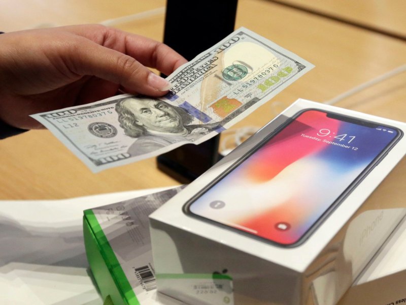 Kunde bezahlt ein iPhone X im Apple Store mit einem Geldschein.