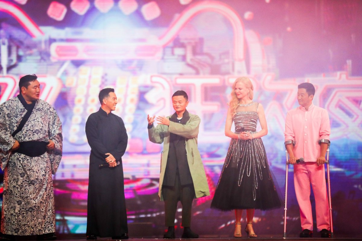 Der Chef von Alibaba steht mit seinen Gästen auf einer Bühne.