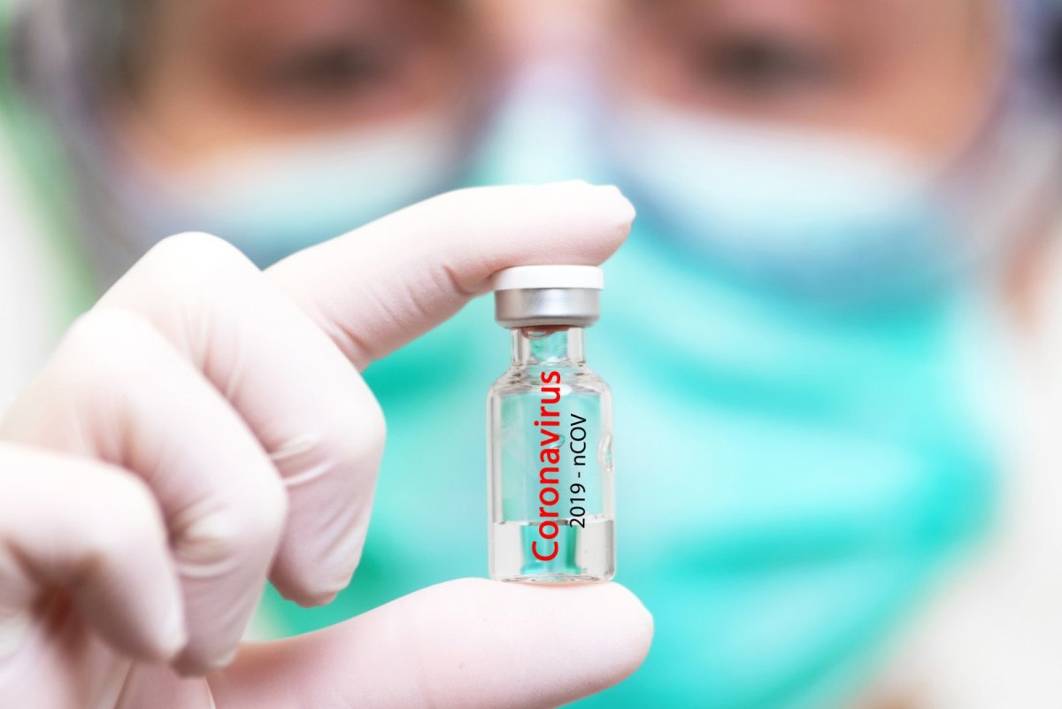 Frau hält Ampulle mit Coronavirus-Impfstoff
