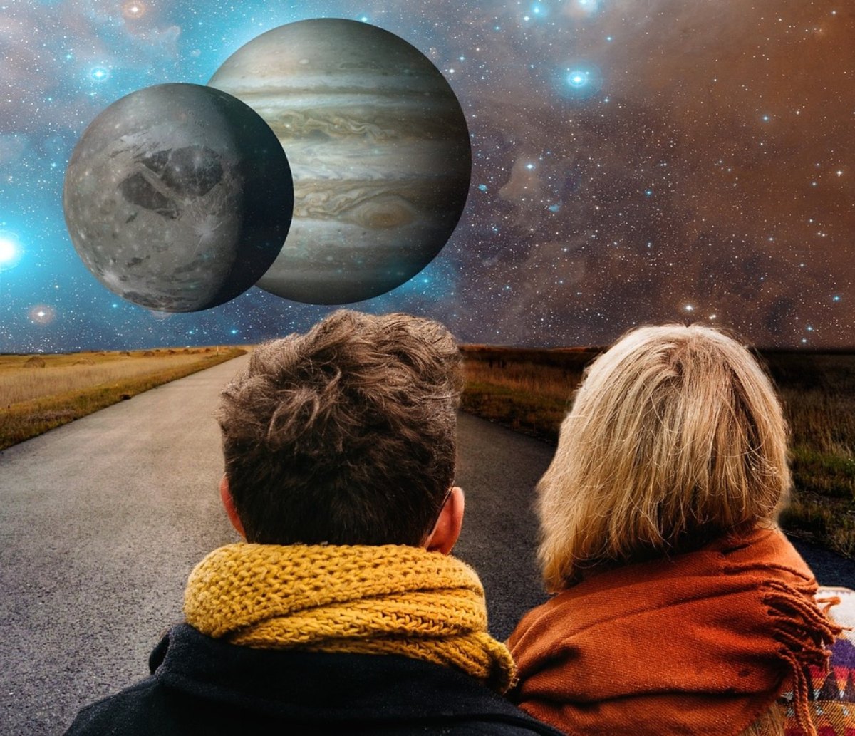 Mann und Frau stehen auf einer Straße und sehen ins All mit zwei Planeten