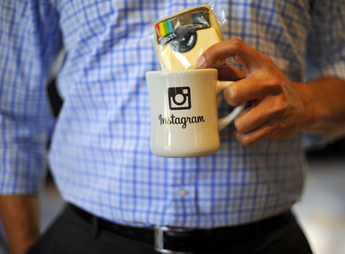 Mann hält Instagram-Tasse