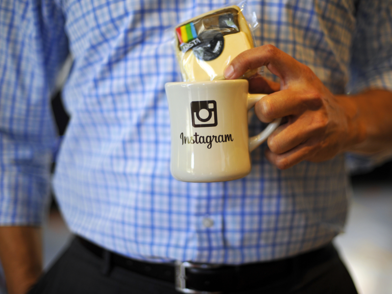 Mann hält Instagram-Tasse