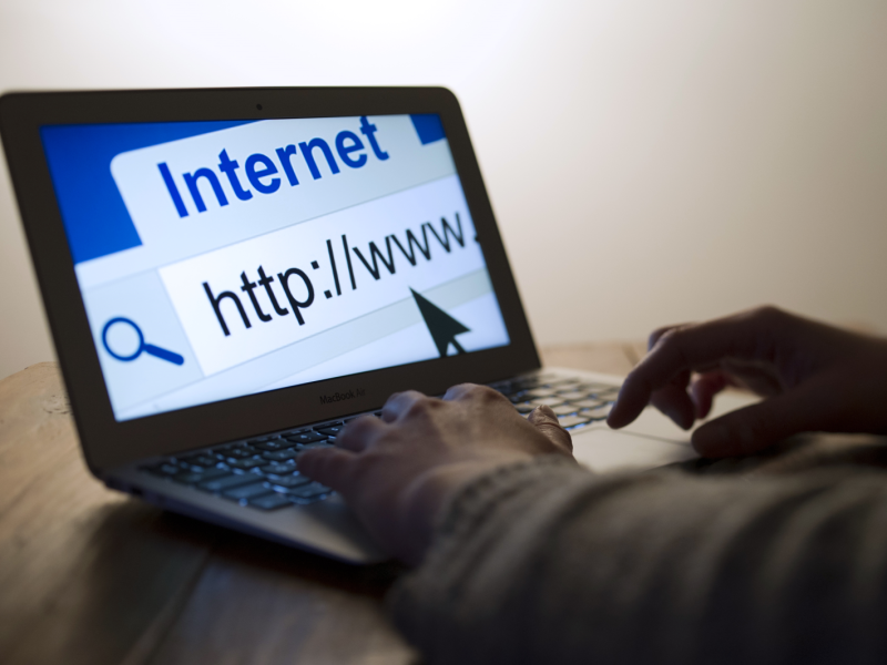 Aufgeklappter Laptop zeigt das Wort Internet und den Anfang einer URL