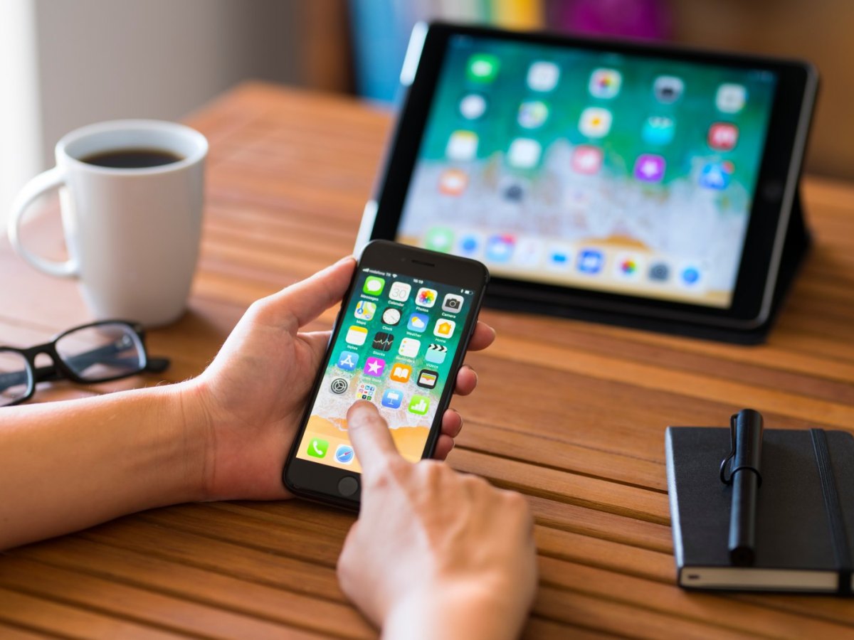 iPad und iPhone auf Holztisch.