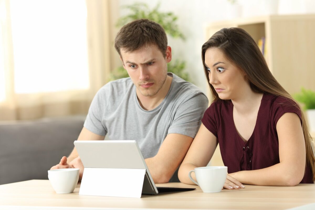 Ein Mann und eine Frau blicken ungläublig und erstaunt auf ein iPad.