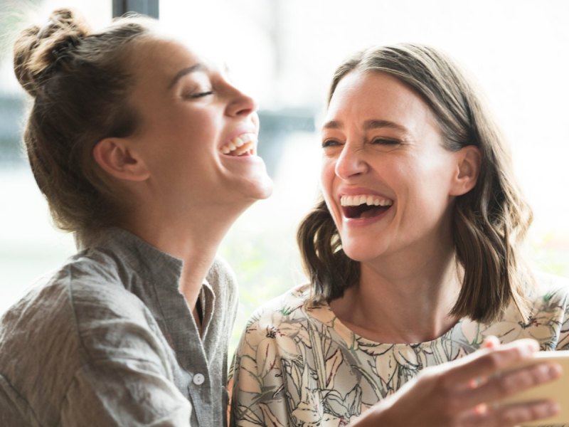 Zwei Frauen lachen mit Handy